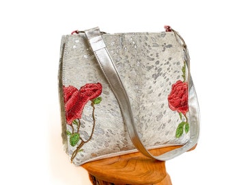 Elegant silver and white hair-on cowhide shoulder bag with embroidered red roses and silver leather trim