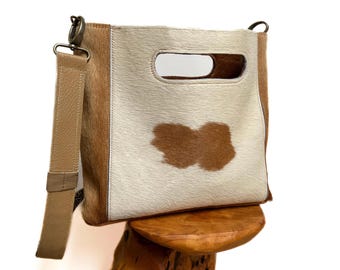 Bolso con asa de piel de vaca con pelo moteado y correa de guitarra extraíble.