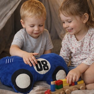 Two children playing together with colorful race car plush pillow, fun kids bedroom accessory, gift for little motorsport fans