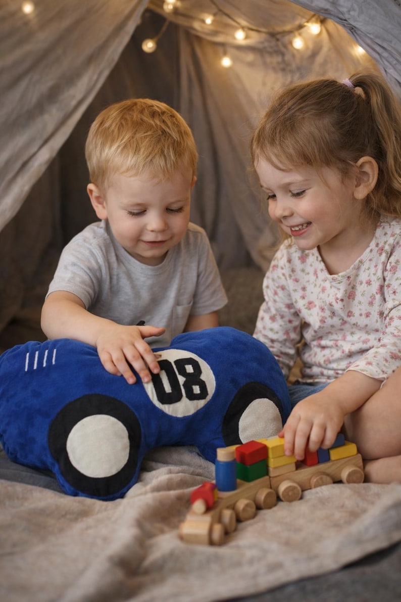 Two children playing together with colorful race car plush pillow, fun kids bedroom accessory, gift for little motorsport fans