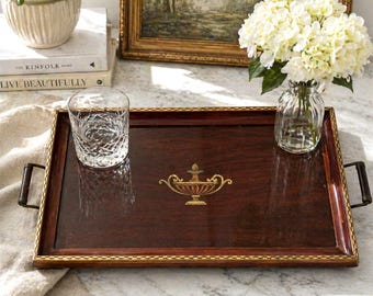 Bandeja de servir grande de madera vintage con tapa de cristal, incrustaciones doradas, diseño de urna y asas. En excelente estado.