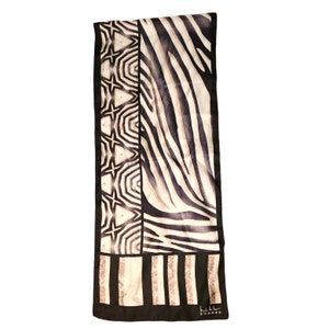 Könnte beinhalten: Schwarz-weißer Seidenschal mit Zebra-Muster und geometrischem Muster. Der Schal hat einen schwarzen Rand und den Text "L.L.Bean" in Weiß.