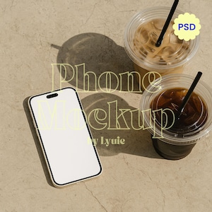 Pode incluir: Maquete de smartphone branco com borda preta, posicionado ao lado de duas bebidas de café gelado em copos de plástico transparente com canudos pretos. A imagem tem o texto "Phone Mockup by Lyuie" em amarelo, e um adesivo "PSD".