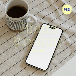 May include: A smartphone with a blank white screen rests on a striped beige cloth next to a mug of coffee. The mug has a white handle and is decorated with vertical black lines. The text "Phone Mockup" is visible.