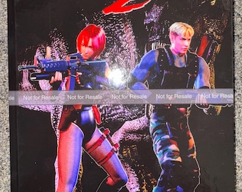 May include: A Dino Crisis 2 video game case featuring a black background with a large dinosaur silhouette. Two characters stand in the foreground, one with red hair holding a rifle and another with blonde hair holding a weapon. Text reads Dino Crisis 2.