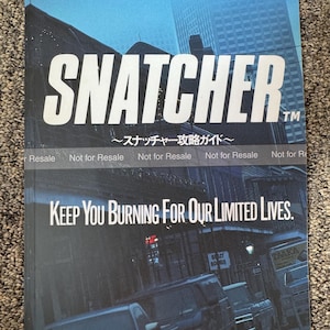 May include: A magazine cover with the title "SNATCHER" in large white letters. The cover has a blue and black color scheme with the text "KEEP YOU BURNING FOR OUR LIMITED LIVES." and "Monthly Magazine PC Engine November, 1992."