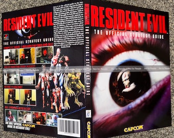 May include: A Resident Evil strategy guide with a red and black cover. The cover features the game's title, a close-up of an eye, and images of characters and scenes from the game. The guide is published by Capcom.
