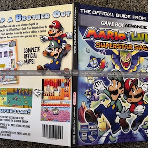 May include: A guide for the Game Boy Advance game "Mario & Luigi: Superstar Saga." The cover features Mario and Luigi, with the title in bold, colorful lettering. The guide promises complete official maps and detailed descriptions.