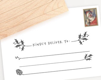 May include: A flat lay featuring a gift wrapped in white paper with a black and white chevron ribbon, a wooden card with the text "KINDLY DELIVER TO:" and a white card with the same text. Gold scissors and a box are also visible.