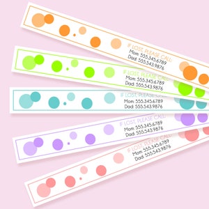 May include: Five rectangular identification wristbands in orange, lime green, teal, purple, and pink. Each band features a matching colored border, a polka dot pattern, and the printed text: IF LOST, PLEASE CALL: Mom: 555.345.6789 Dad: 555.543.9876.