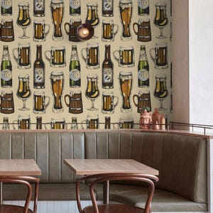 May include: A restaurant interior with a long, beige banquette and four chairs. The wall behind the banquette is covered in a wallpaper pattern of beer bottles and glasses. The wallpaper is in shades of brown, yellow, and green.