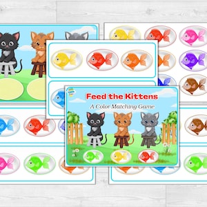 Puede incluir: Un juego de emparejamiento de colores para ni&ntilde;os titulado "Alimenta a los gatitos". El juego presenta ilustraciones de gatitos y peces de colores. Las tarjetas del juego est&aacute;n dispuestas sobre una superficie de vetas de madera clara.