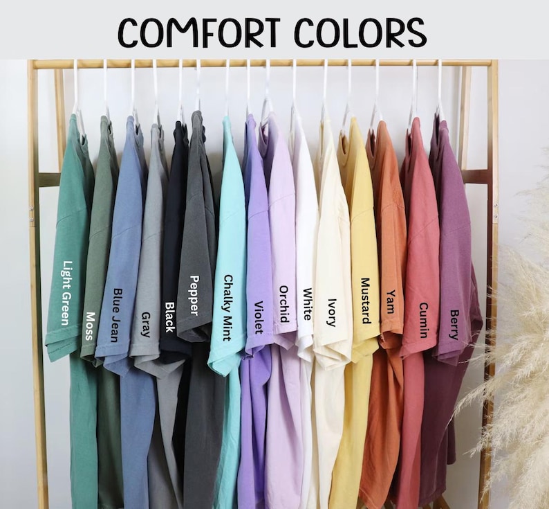 A clothing rack displaying a variety of colorful t-shirts, each with a different color label.