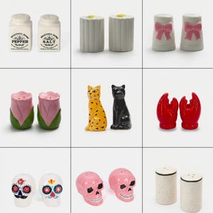 Puede incluir: Una colección de nueve pares de saleros y pimenteros de cerámica con diversos diseños, incluyendo modelos rectangulares blancos con texto, cilindros estriados, lazos rosas, tulipanes, gatos, pinzas de langosta rojas y calaveras.