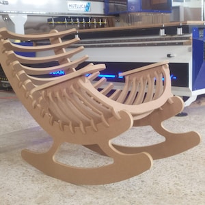 May include: A wooden rocking chair with a unique, open design. The chair is constructed from light brown wood and features a curved seat and backrest with multiple vertical slats. The rocker has a modern, minimalist aesthetic.