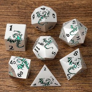 Könnte beinhalten: Ein Set aus sieben silberfarbenen, polyedrischen Würfeln mit grünen Drachendesigns und schwarzen Zahlen. Die Würfel haben verschiedene Formen, darunter ein Würfel, ein d8, ein d10, ein d12, ein d20 und ein Dreieck. Auf einer Holzoberfläche.