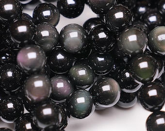 May include: A close-up of a strand of black obsidian beads. The beads are round and have a smooth, polished finish. The obsidian is a dark, opaque stone with a slight iridescent sheen.