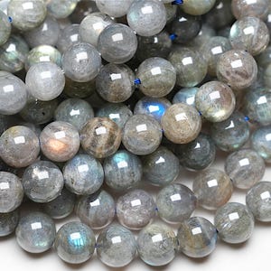 Könnte beinhalten: Eine Schnur runder, grauer Labradorit-Edelsteinkugeln mit irisierenden Farbschimmern. Die Kugeln haben einen Durchmesser von etwa 8 mm.