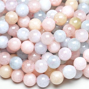 Peut inclure: Un brin de perles rondes et lisses de pierres précieuses aux couleurs pastel. Les perles sont un mélange de bleu clair, de rose et de jaune.
