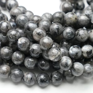 May include: A close-up of a strand of gray labradorite gemstone beads. The beads are round, with a polished finish, and display a mix of gray and black tones. The beads are approximately 8mm in diameter, suitable for jewelry making.