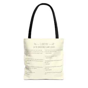 May include: A white tote bag with black handles. The bag features a design with the text "I Love You In The Inheritance Games Quotes" and several quotes from the book.