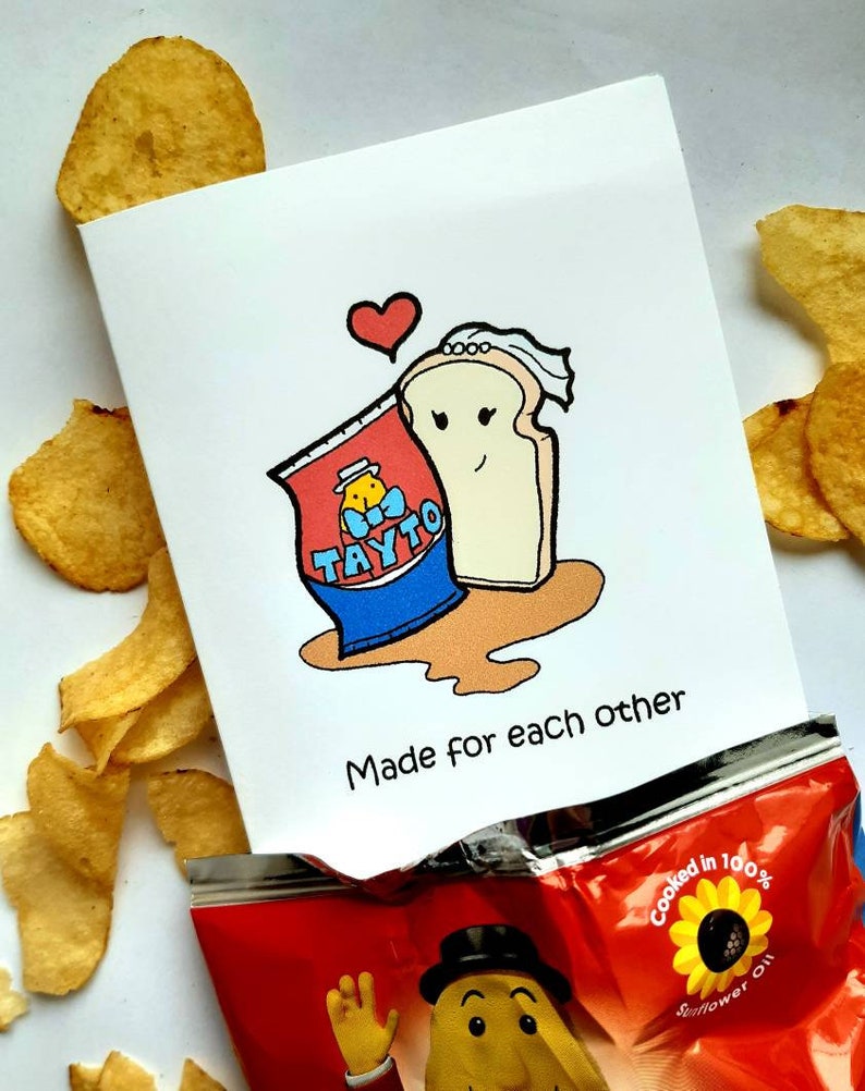 Peut inclure: Une carte blanche avec une illustration de dessin anim&eacute; d'un sac de chips Tayto et une tranche de pain avec un voile. Le texte "Made for each other" est &eacute;crit sous l'illustration.