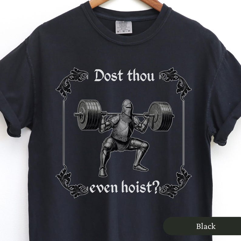Pode incluir: Camiseta preta com um cavaleiro medieval levantando pesos. O texto na camiseta diz "Dost thou even hoist?"