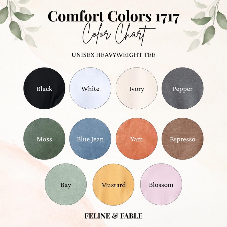 May include: Color chart for Comfort Colors 1717 unisex heavyweight tees. The chart displays a range of colors, including black, white, ivory, pepper, moss, blue jean, yam, espresso, bay, mustard, and blossom. The brand name "FELINE & FABLE" is at the bottom.
