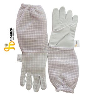 May include: White beekeeping gloves with a mesh sleeve. The gloves have a white leather palm and fingers, and a mesh sleeve that extends up the forearm. The gloves are designed to protect the wearer from bee stings. The brand name "HASHMI BEE APPAREL" is visible.