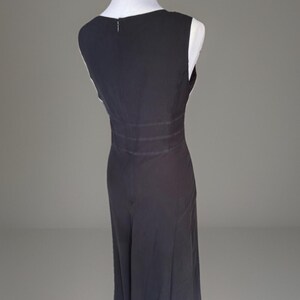 Puede incluir: Vestido sin mangas, gris oscuro, exhibido en un maniqu&iacute;. El vestido presenta un escote en V, una cintura entallada con detalles horizontales y una falda fluida. El dobladillo est&aacute; rematado con un ribete decorativo.