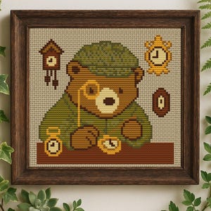 May include: Cross-stitch art of a bear wearing a green hat and monocle, surrounded by clocks and a cuckoo clock. The bear is brown and tan, with a green outfit. The artwork is framed in a dark brown wooden frame.
