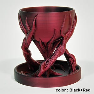 May include: A decorative, dark red and black planter with a unique, organic design. The planter features a bowl-shaped top supported by intertwined, branch-like structures. The base is a circular tray. The text "color: Black+Red" is visible at the bottom.