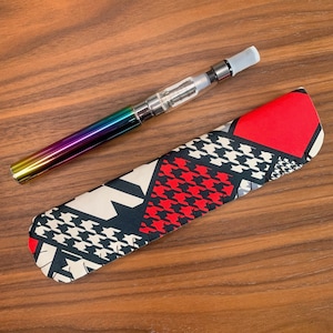 May include: A black and white patterned fabric case with red accents for a silver and rainbow colored electronic cigarette.