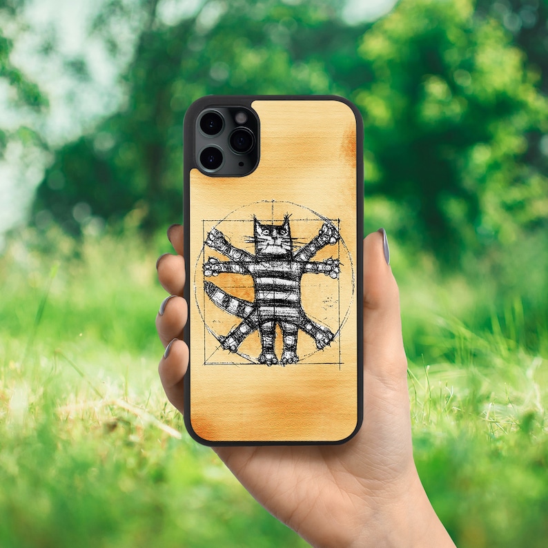 K&ouml;nnte beinhalten: Eine schwarze Handyh&uuml;lle mit Holzmaserung. Die H&uuml;lle zeigt eine Schwarzwei&szlig;illustration einer Katze in einem Kreis mit geometrischem Muster.