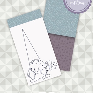 Può includere: Illustrazione di uno gnomo che tiene un fiore, con il testo "Gnome rice bags" e "pdf pattern". L'immagine presenta due carte decorate, una blu e una viola, su uno sfondo geometrico.