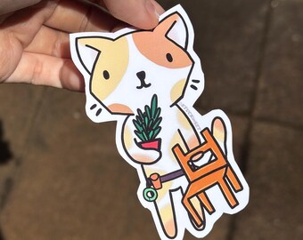 Puede incluir: Una pegatina con un gato de dibujos animados con pelaje naranja y blanco, sosteniendo una planta en maceta y una pequeña silla naranja. El gato tiene un cinturón de herramientas y está sonriendo. La pegatina tiene un borde blanco.