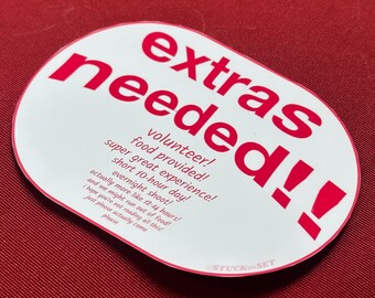 Puede incluir: Pegatina ovalada blanca con texto rosa que dice "extras needed!!" e incluye el texto "volunteer! super great experience! food provided! short 10-hour day! actually more like 12-14 hours! overnight shoot! and we might run out of food! I hope you're not reading all this! just please actually come please" en rosa más pequeño.