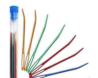 May include: A set of seven colorful plastic needles in a clear plastic tube with a blue lid. The needles are arranged in a fan shape and are all bent at the tip.