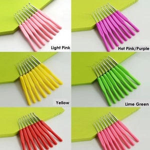 May include: Set of 10 crochet hooks in various colors, including light pink, hot pink/purple, yellow, lime green, red, and dark pink. The hooks are arranged in rows on a green surface.