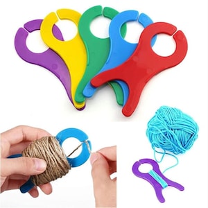 May include: Set of five colorful plastic yarn holders. The holders are shaped like a person with a loop at the top for holding yarn. The holders are purple, yellow, green, blue, and red.