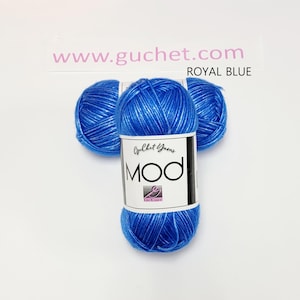 May include: Three skeins of royal blue yarn arranged in a cluster. Each skein features a white paper label with the text Guchet Yarns MOD and a logo. The text www.guchet.com and the words ROYAL BLUE are printed above the yarn on the background.