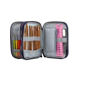 May include: A navy blue zippered case with a floral pattern, open to reveal a variety of crochet hooks, knitting needles, and a pink ruler with measurement markings.