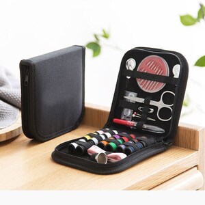 May include: A black zippered case containing a selection of sewing essentials, such as needles, thread, a thimble, and scissors.