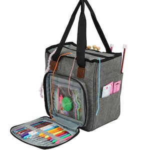May include: A gray canvas tote bag with multiple pockets and compartments for storing knitting needles, yarn, and other craft supplies. The bag has a zippered closure and a top handle.