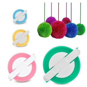 May include: Five colorful pom-pom makers in blue, yellow, pink, and green. The pom-pom makers are round with a white center and two white arms that cross over each other. There are five colorful pom-poms hanging above the pom-pom makers.