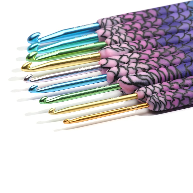 May include: A set of 10 crochet hooks with colorful, patterned handles. The hooks are made of metal and have a variety of sizes, ranging from 3.5 mm to 8 mm. The handles are decorated with a floral design in shades of purple, pink, and blue.