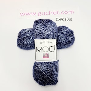 May include: Three skeins of dark blue yarn with a metallic silver sheen, arranged in a cross shape. A white paper label wraps around the center, featuring the text Crochet Yarns, MOD, and the website www.guchet.com, with the label text DARK BLUE.