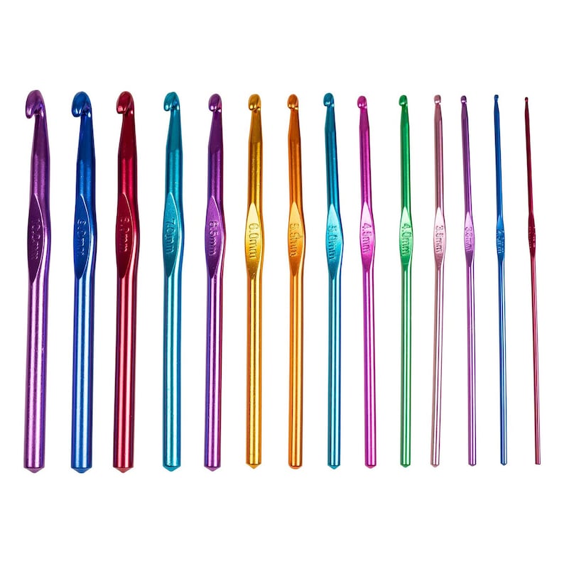 Op de afbeelding: Een verzameling kleurrijke haaknaalden in verschillende maten. De haken zijn gemaakt van metaal en hebben een gladde, glanzende afwerking. De kleuren zijn paars, blauw, rood, teal, goud, oranje, groen en roze. De haken zijn in een rij gerangschikt, met de haakmaten duidelijk aangegeven.