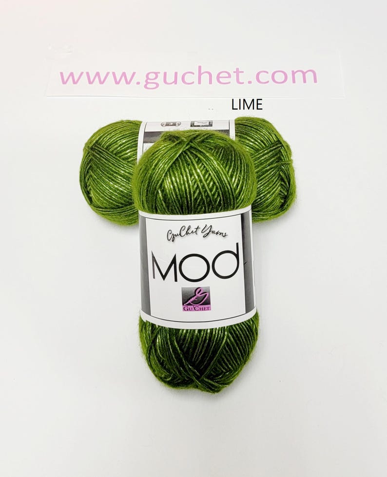 May include: Three skeins of lime green yarn arranged in a cluster. Each skein features a white paper label with the text Guchet Yarns MOD and a logo. The text www.guchet.com and the word LIME are printed above the yarn on the white background.