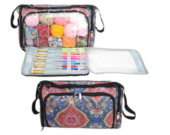 May include: A large, paisley patterned knitting bag with a clear zippered compartment for yarn and a separate compartment for knitting needles. The bag has a black shoulder strap and a zipper closure.